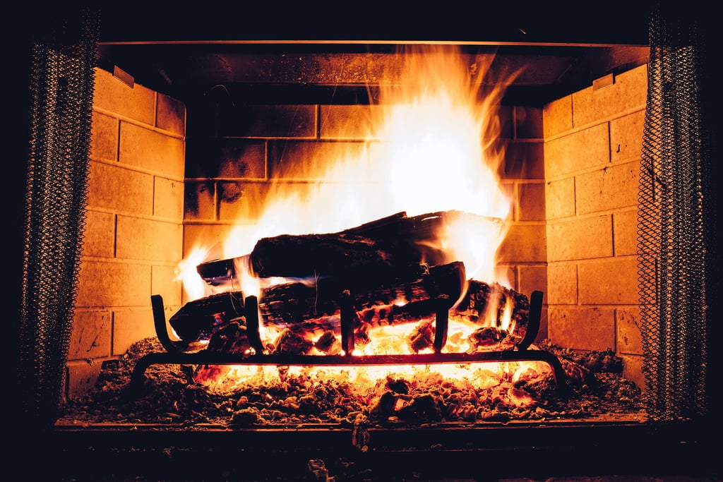 Flames rising around logs in a fireplace