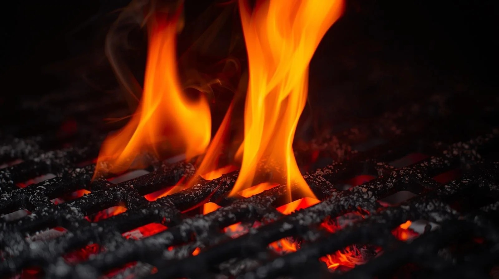 Wood burning beneath a cooking grill