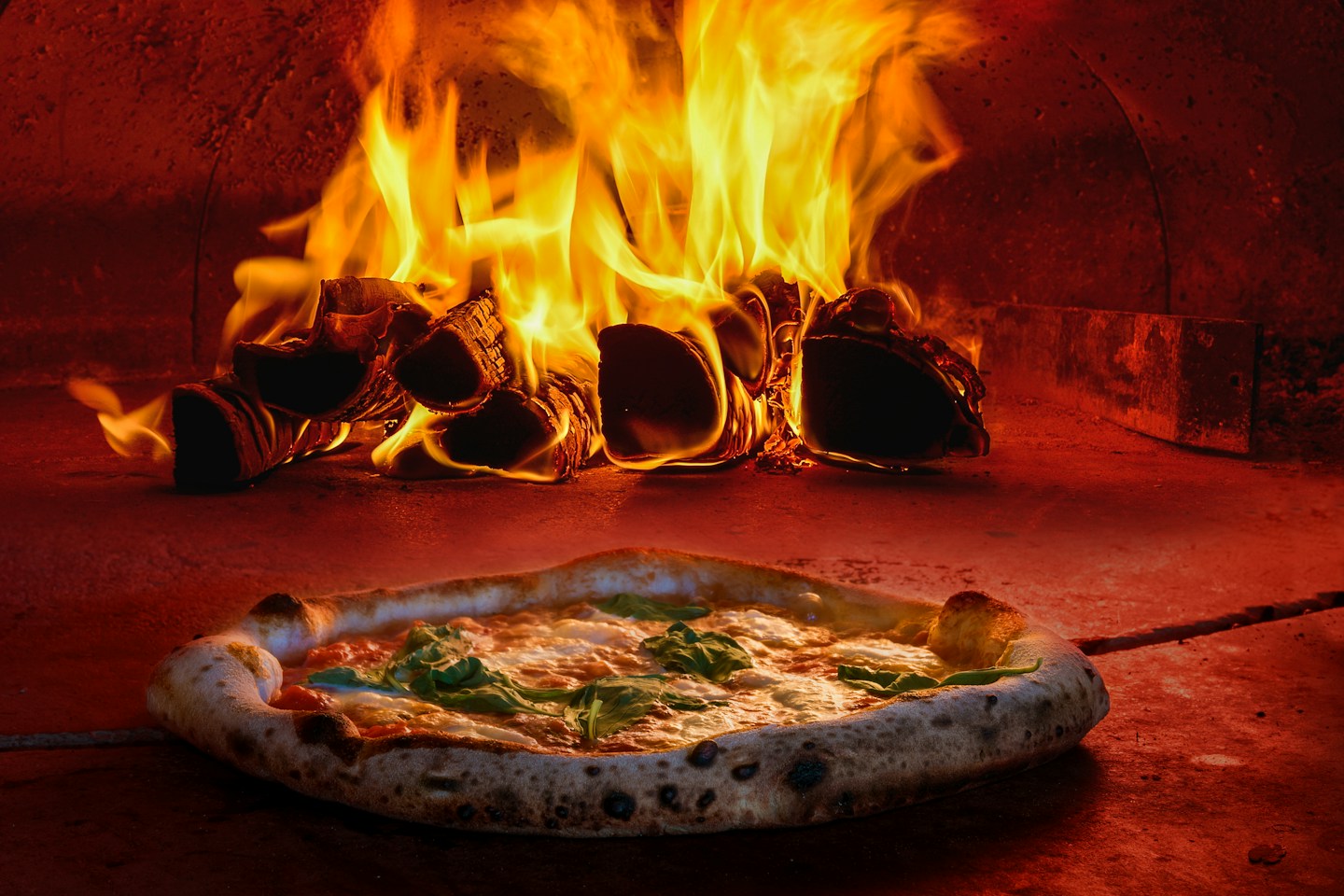 Wood fire burning inside a pizza oven